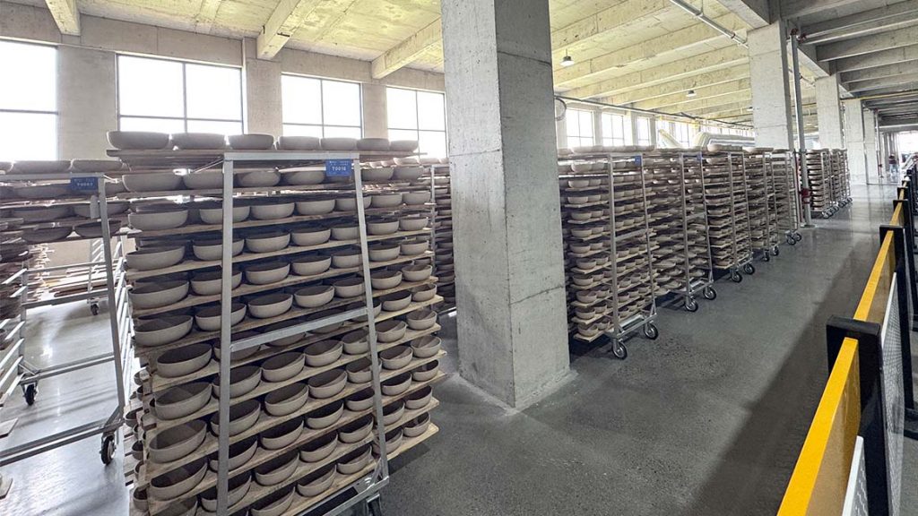 Ceramic bowl bodies arranged on production racks inside the factory
